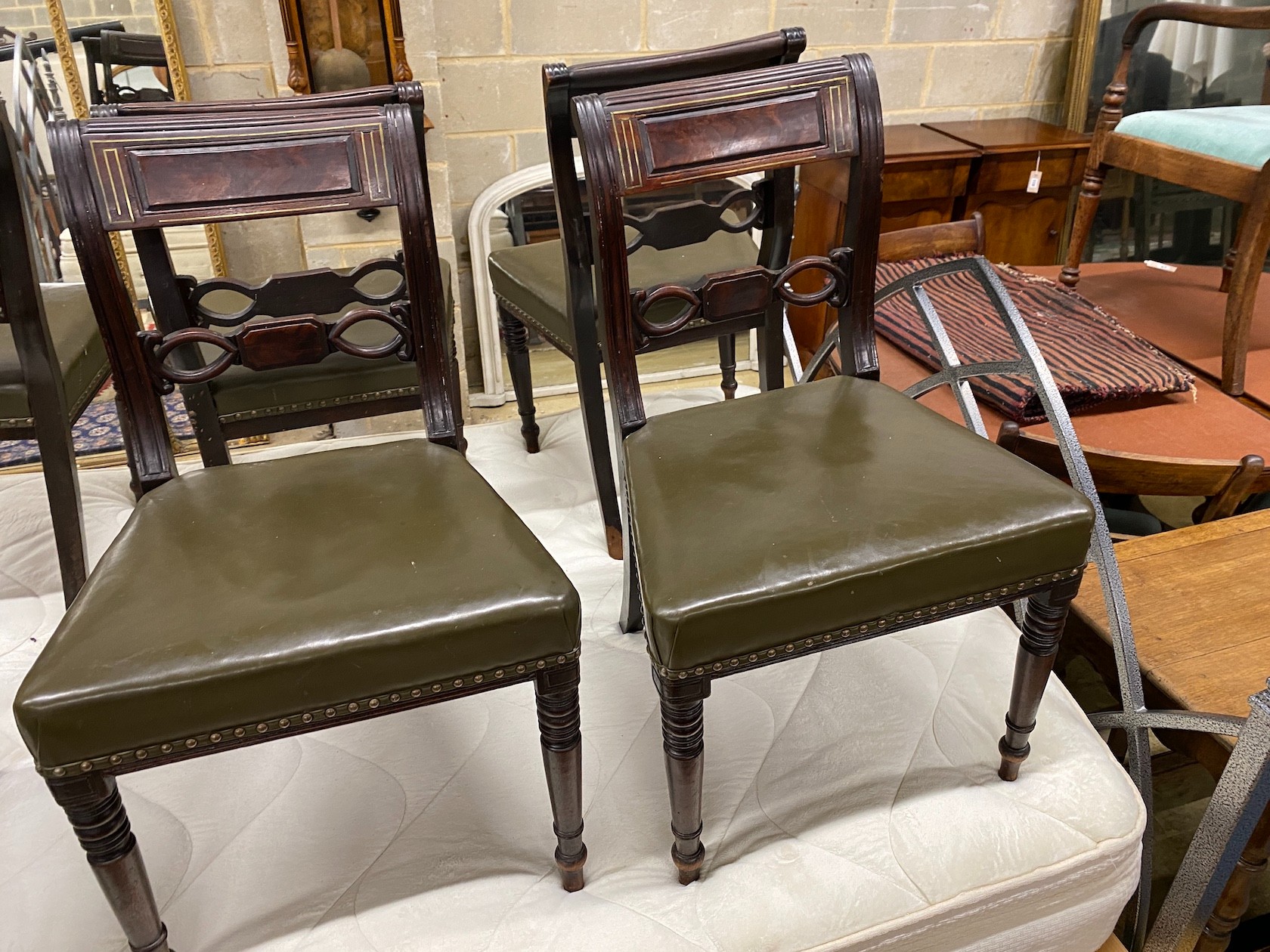 A set of six Regency brass inlaid mahogany dining chairs with green leather seats